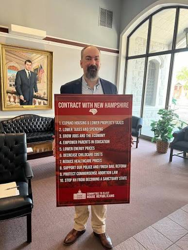 Jason Osborne holding the Contract With New Hampshire